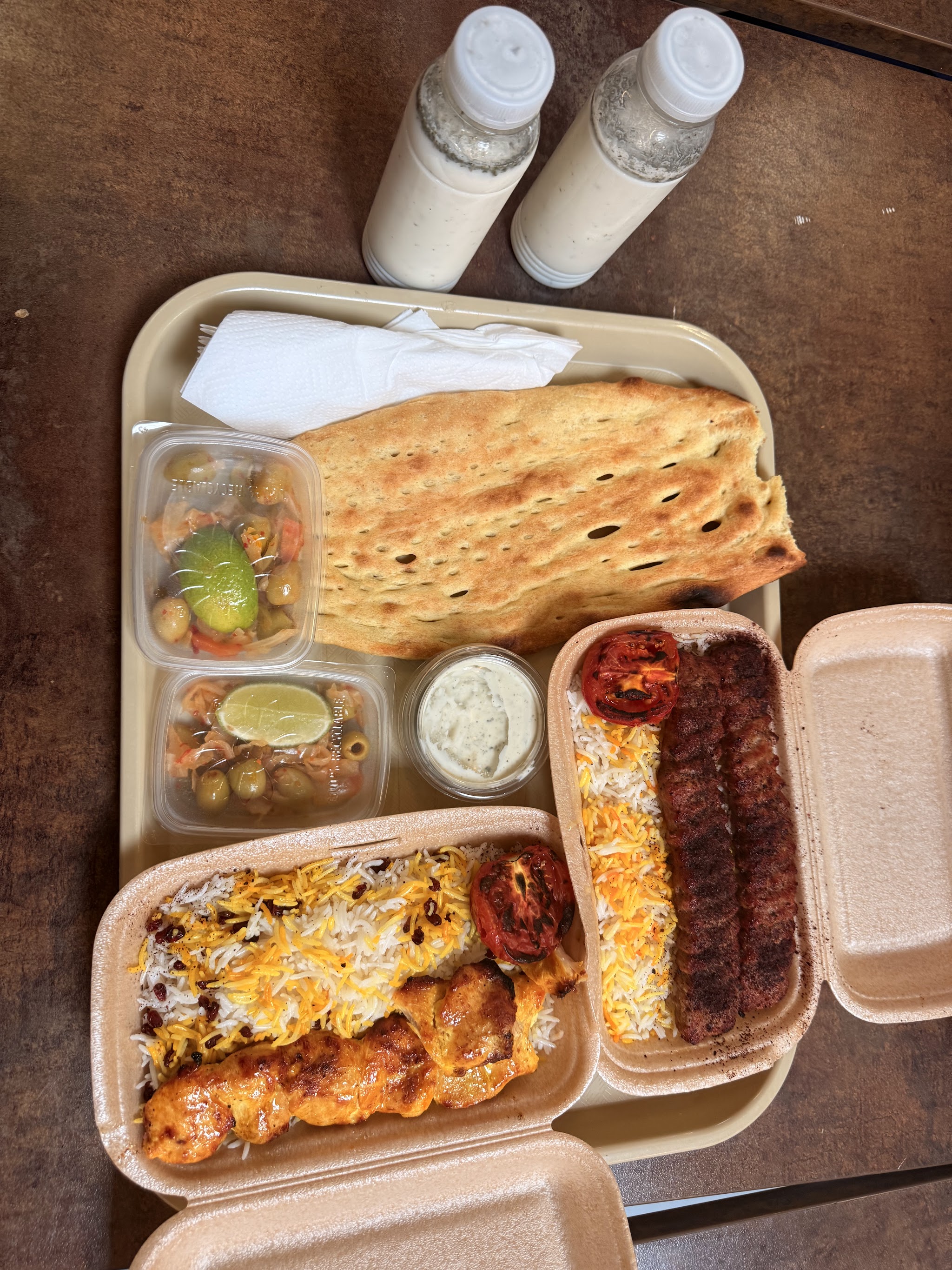 Kebab, rijst, brood en bijgerechten samen op tafel